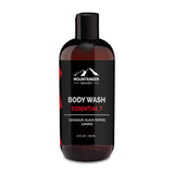 A bottle of Mountaineer Brand Products all natural men's body wash, with geranium, black pepper, and juniper scents, 12 fl oz size, on a white background.