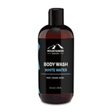 A bottle of Mountaineer Brand Products Natural Men's Body Wash labeled "white water" with mint, cedar, and musk scents, 12 fl oz (355 ml).